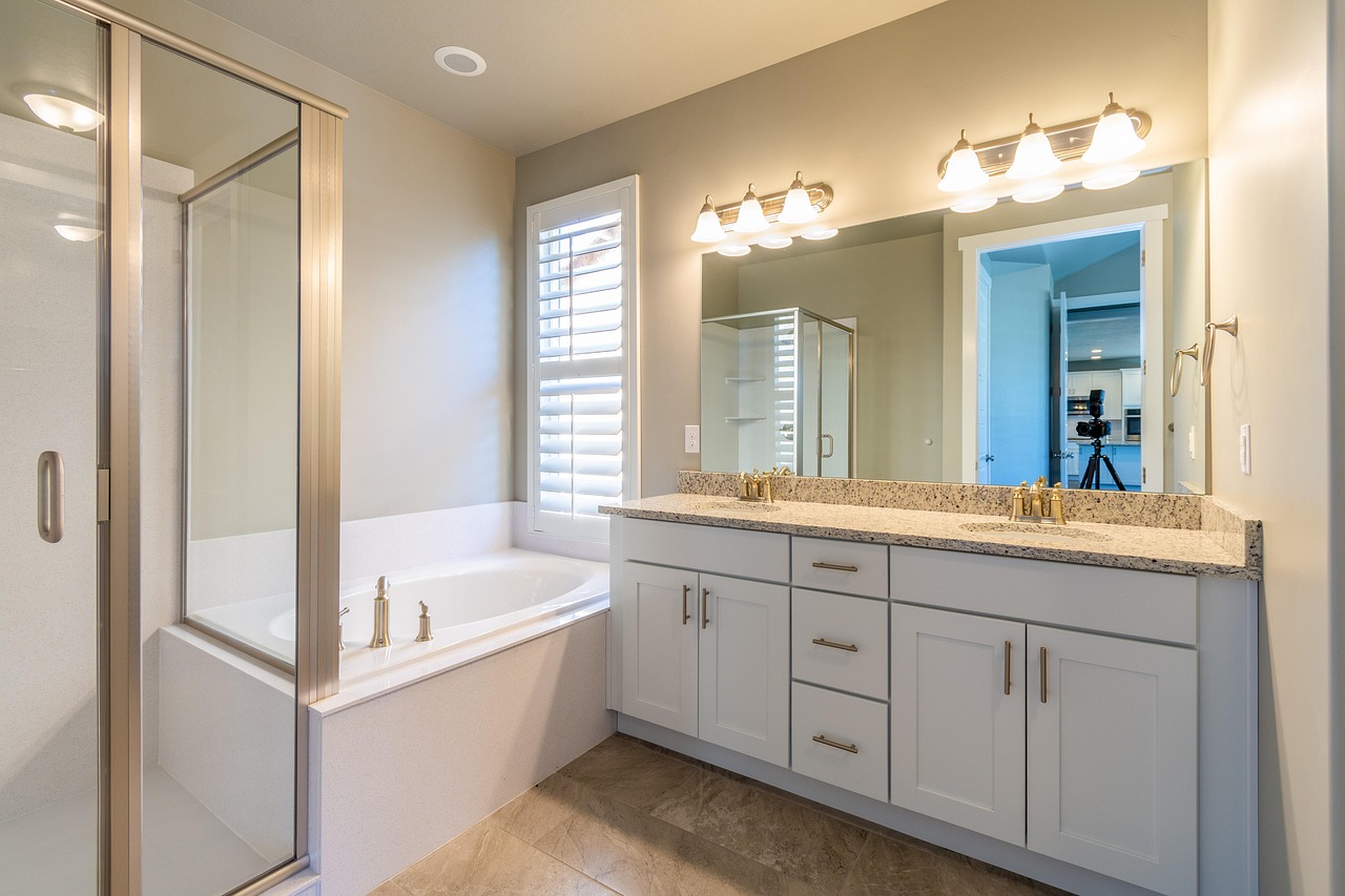 Remodeled bathroom with warm sand-colored tile, a walk-in shower and a wood vanity